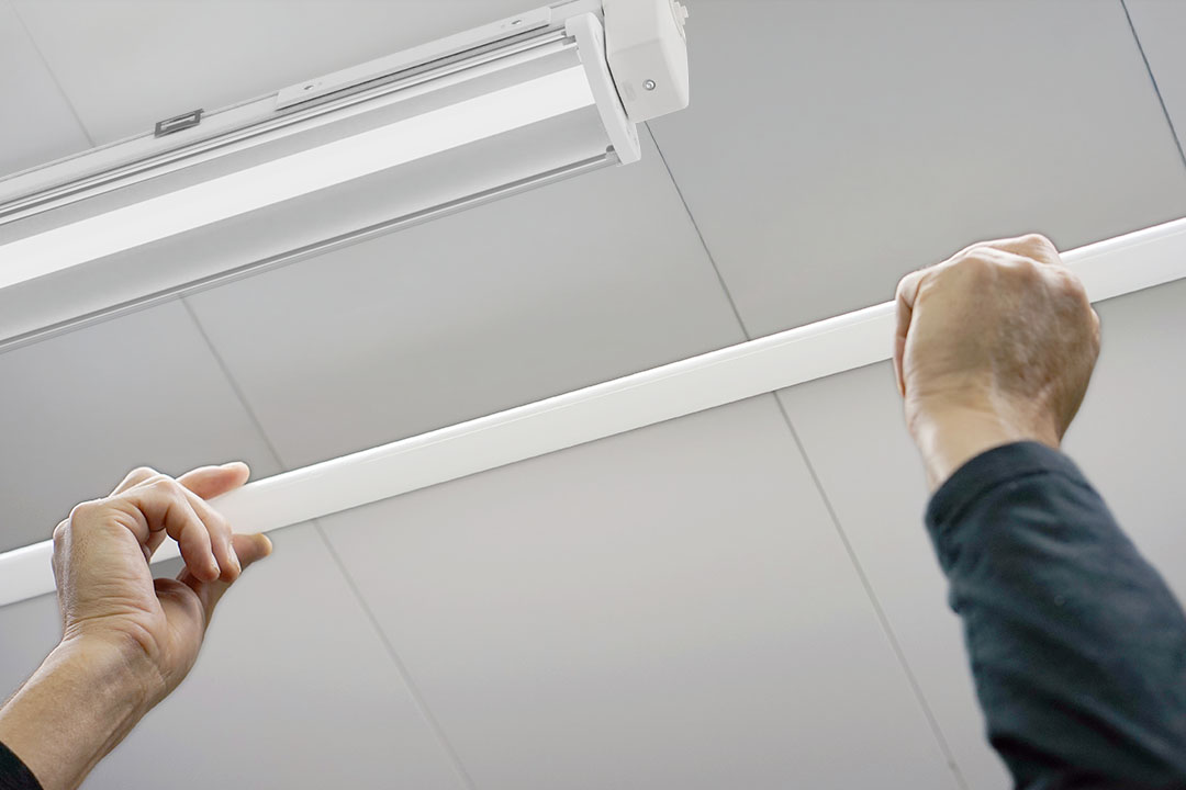 Man holds fluorescent tube in front of LED lamp