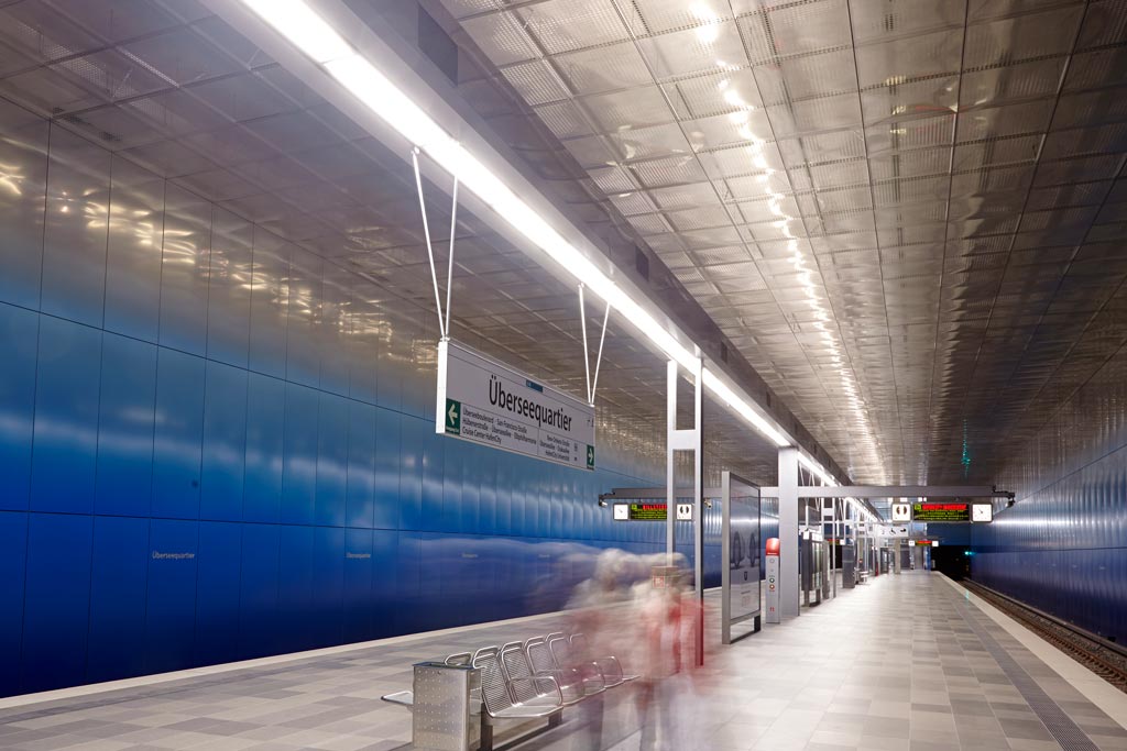 U-Bahn-Station Überseequartier mit moderner, gleichmäßiger und blendarmer LED-Beleuchtung; helle Ausleuchtung des Bahnsteigs für sichere Orientierung und angenehme Aufenthaltsqualität.