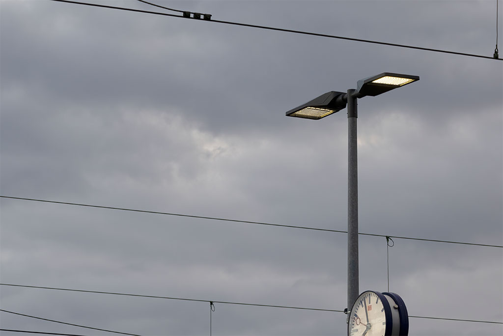 Pole-mounted luminaire with a double arm on the platform